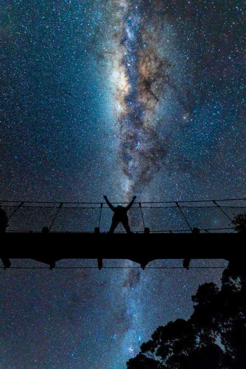 Astrophotography woman on bridge at Kaiaraara Hut on Aotea Track